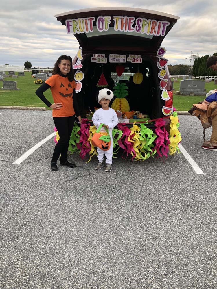 Lady and kids in costume standing infront of car